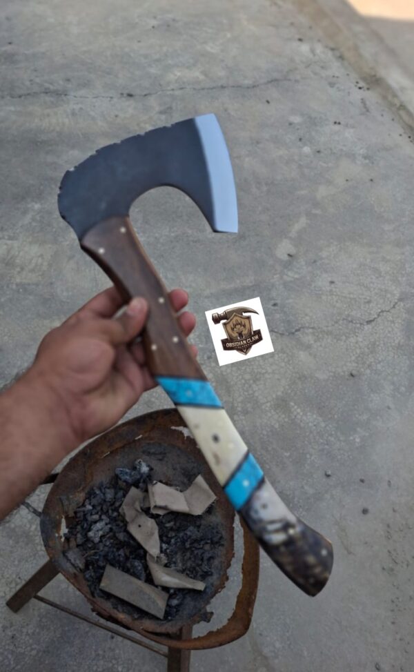 Handmade 1095 high carbon steel vikings  throwing hatchet  with leather cover. 
Handle made with the combination  of ram horn and camel bone and rose wood scales . Blue Turkish spacers.  Approximately  17 inches long.
6 inches head width. - Image 2